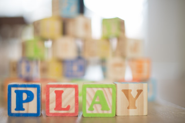 A child working on a wooden puzzle, practicing fine motor skills and hand-eye coordination.